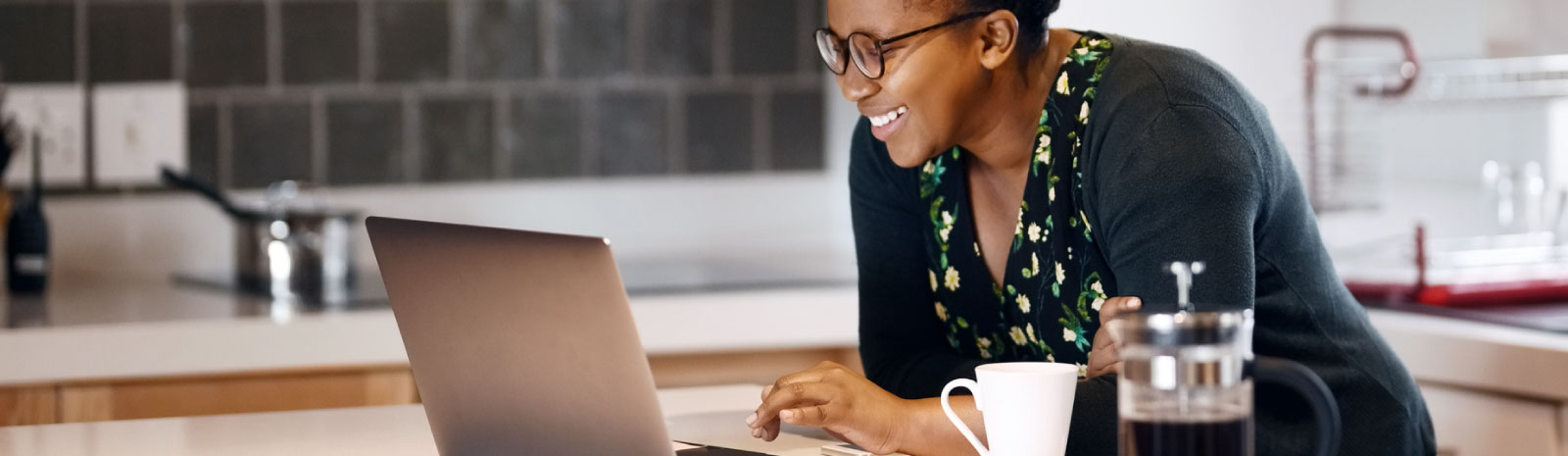 Woman at a computer in her kitchen.