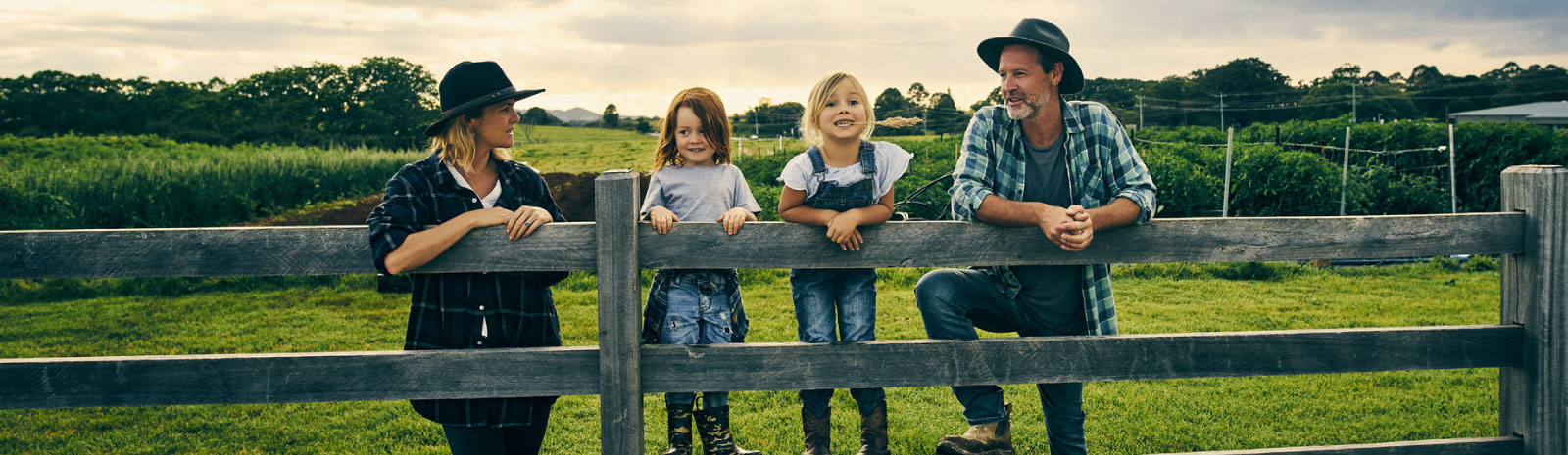 Family at fence on farm.