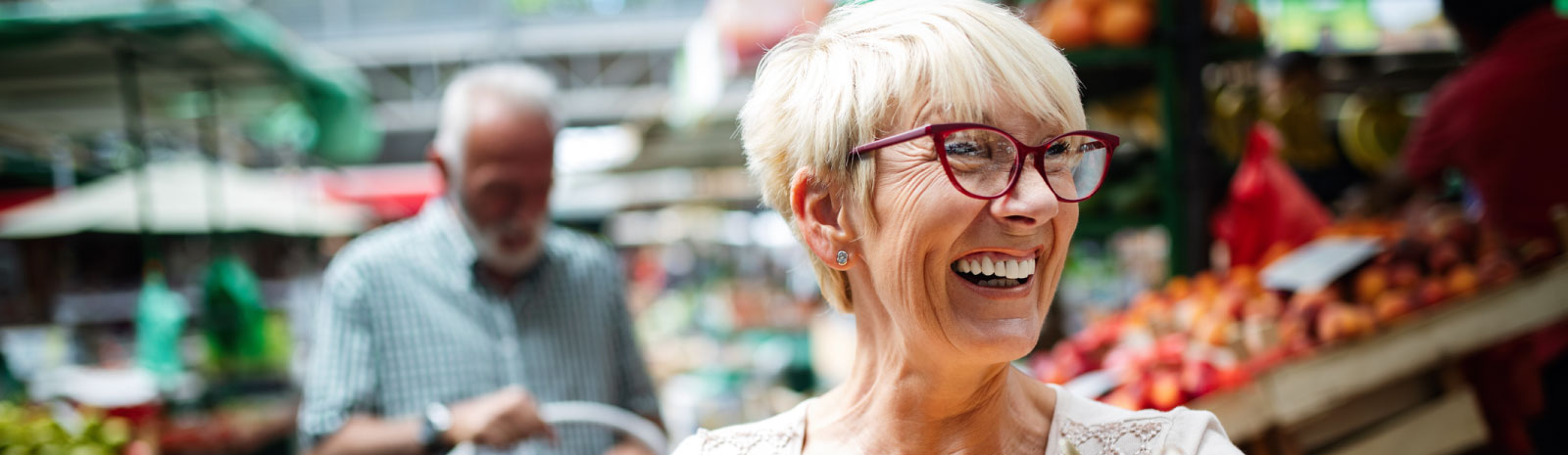 Mature woman at the market while husband follows shortly behind.